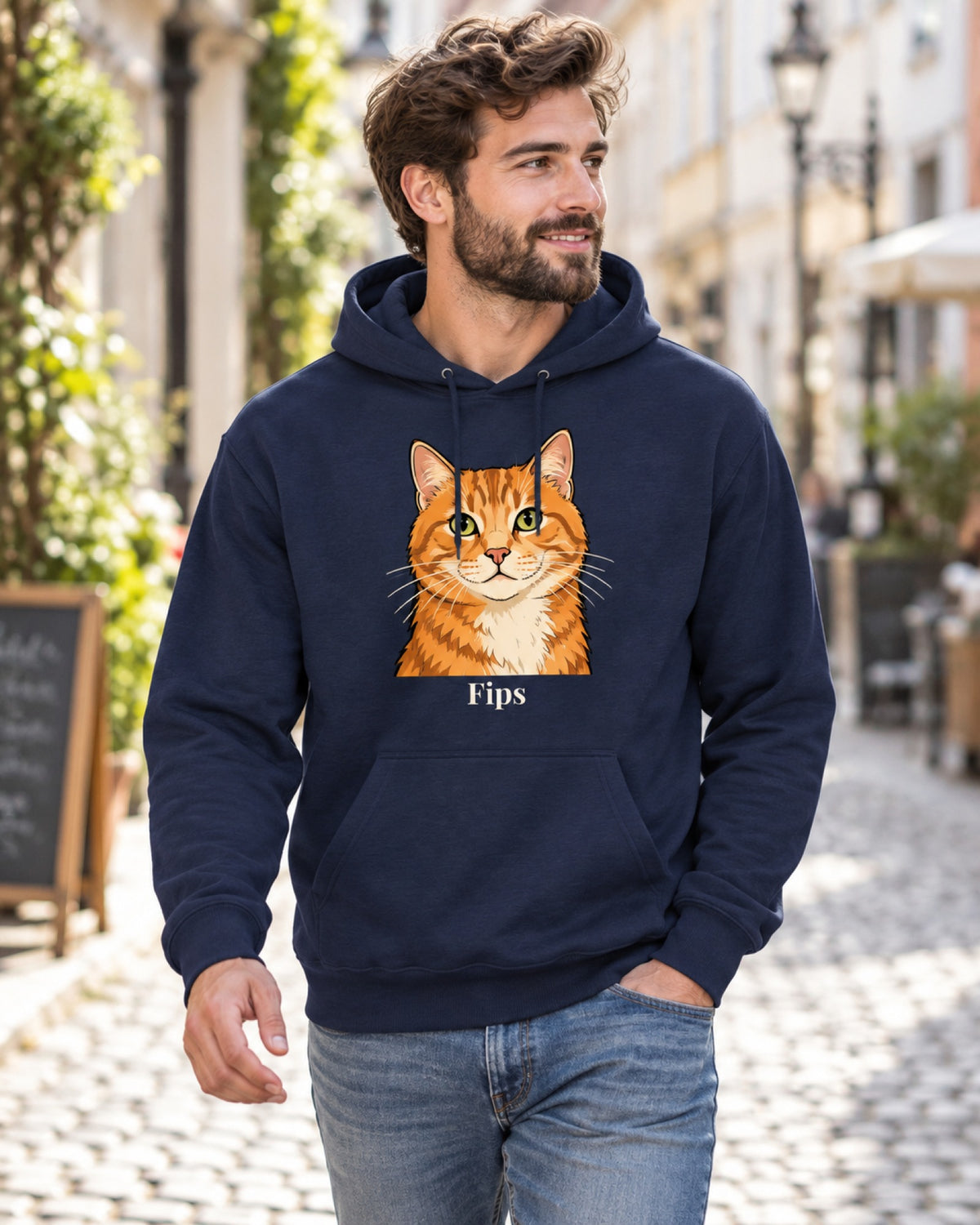 Navy Hoodie mit roter Tigerkatze im Cartoon-Stil und Namen Fips, ein Mann geht durch eine Altstadtgasse