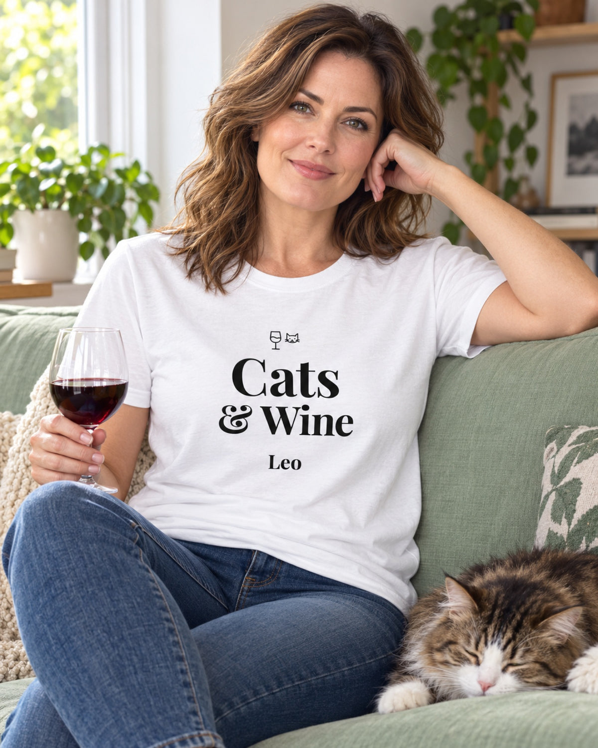 Weißes T-Shirt Cats und Wine mit Namen Leo, die Frau mit Rotweinglas sitzt auf dem Sofa, daneben schläft ihre Katze