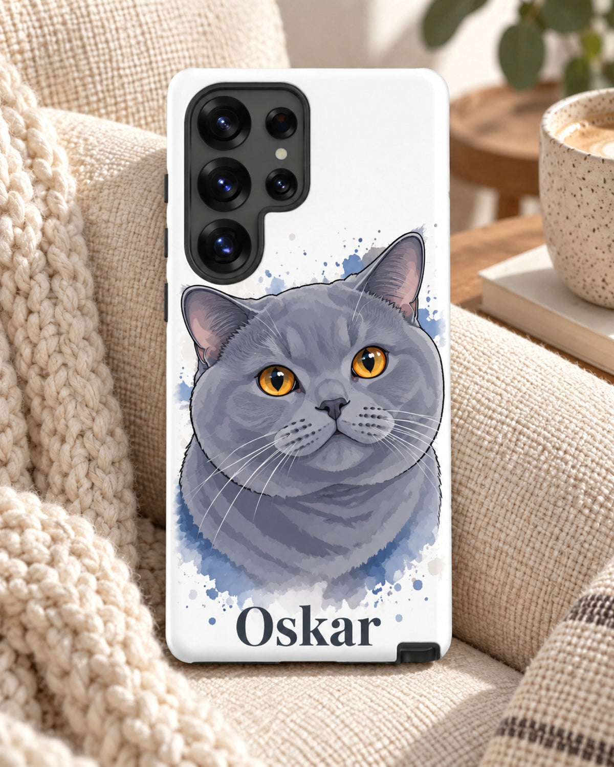 Samsung-Hülle mit Britisch Kurzhaar im Aquarell-Stil und Namen Oskar, das Handy liegt auf einem Sessel mit Strickdecke