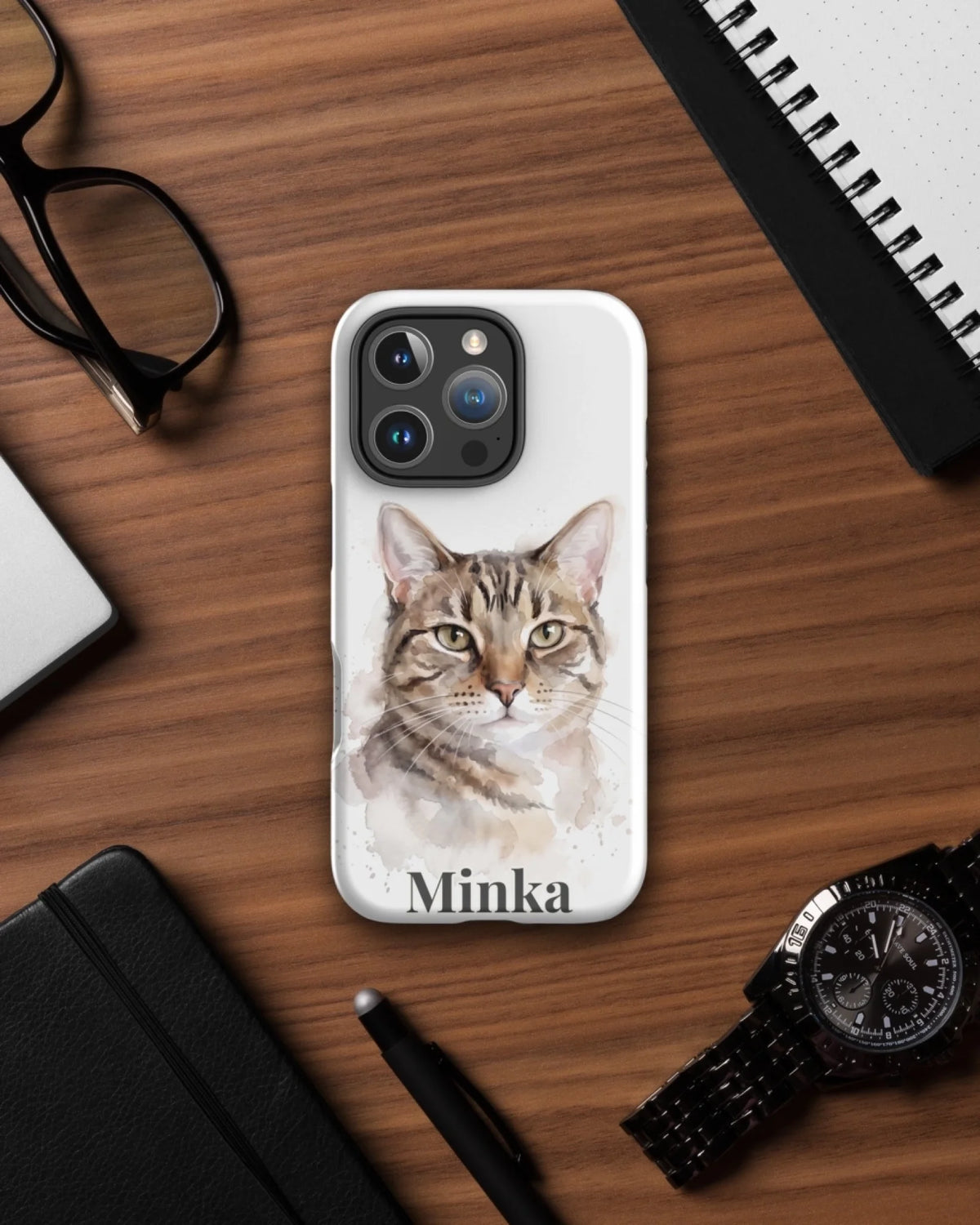 iPhone-Hülle mit Katzenportrait im Aquarell-Stil und Namen Minka auf dem Schreibtisch