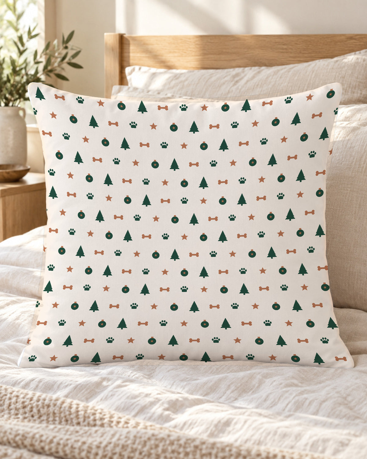 Kissen mit weihnachtlichem Pfotenmuster in Creme auf dem Bett
