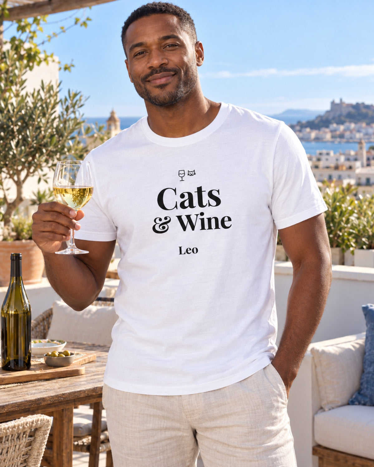 Mann im weißen Cats and Wine T-Shirt mit Beispielname Leo auf einer Sommerdachterrasse
