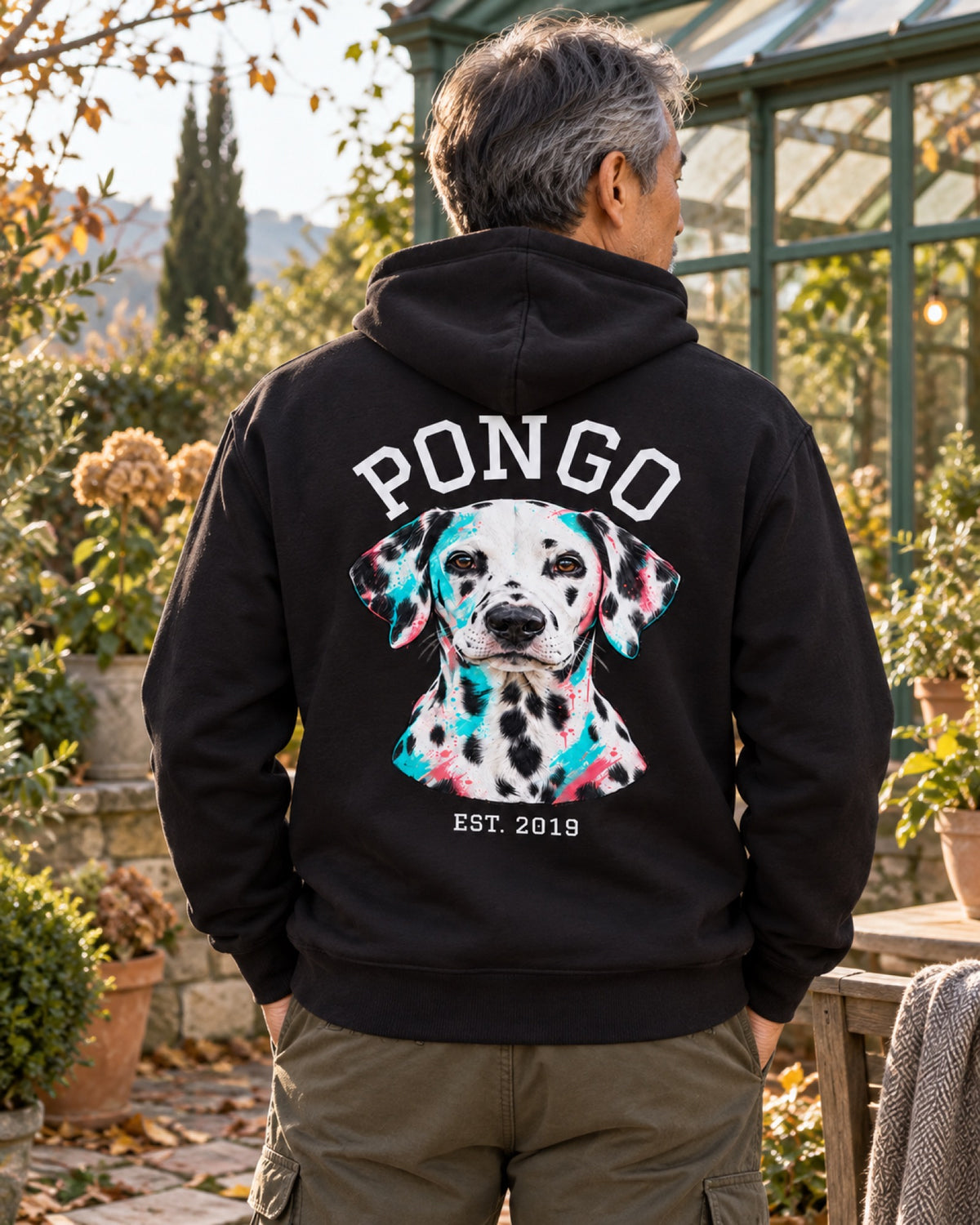 Rückenansicht eines schwarzen Hoodies mit Dalmatiner Pongo als Pop-Art-Portrait im meergrünen Herbstwintergarten