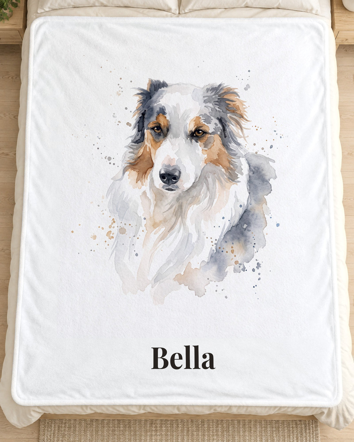 Kuscheldecke mit Hundeportrait im Aquarell-Stil und Namen Bella auf dem Bett